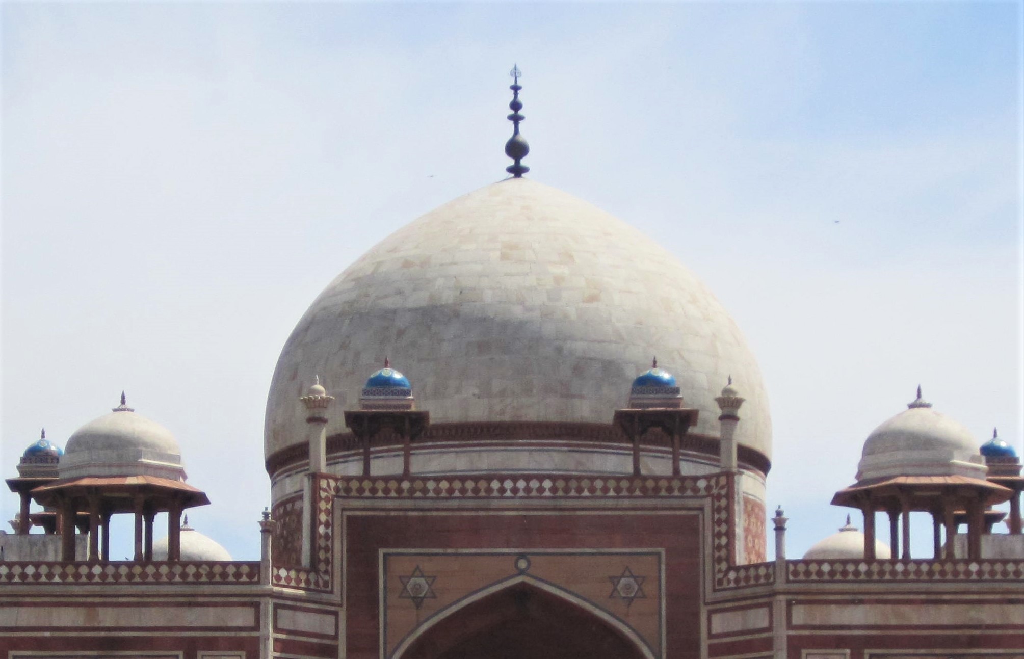 The 125ft tall marble-covered central dome with a copper brass finial.